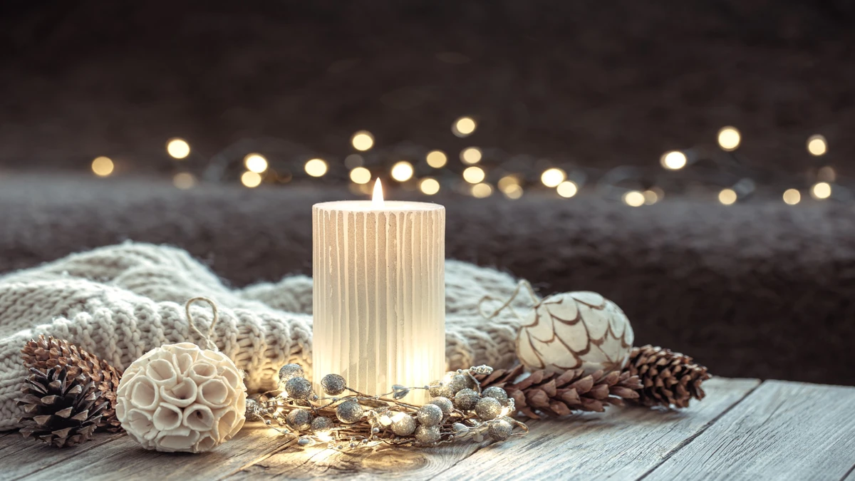 winter-festive-background-with-burning-candle-home-decor-details-blurred-background-with-bokeh