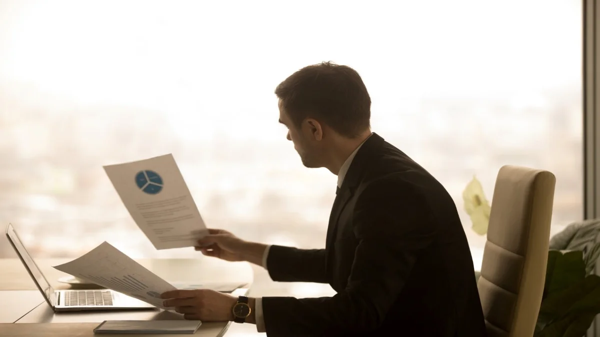 A businessman looks at a report, which Double Iron Consulting can help with